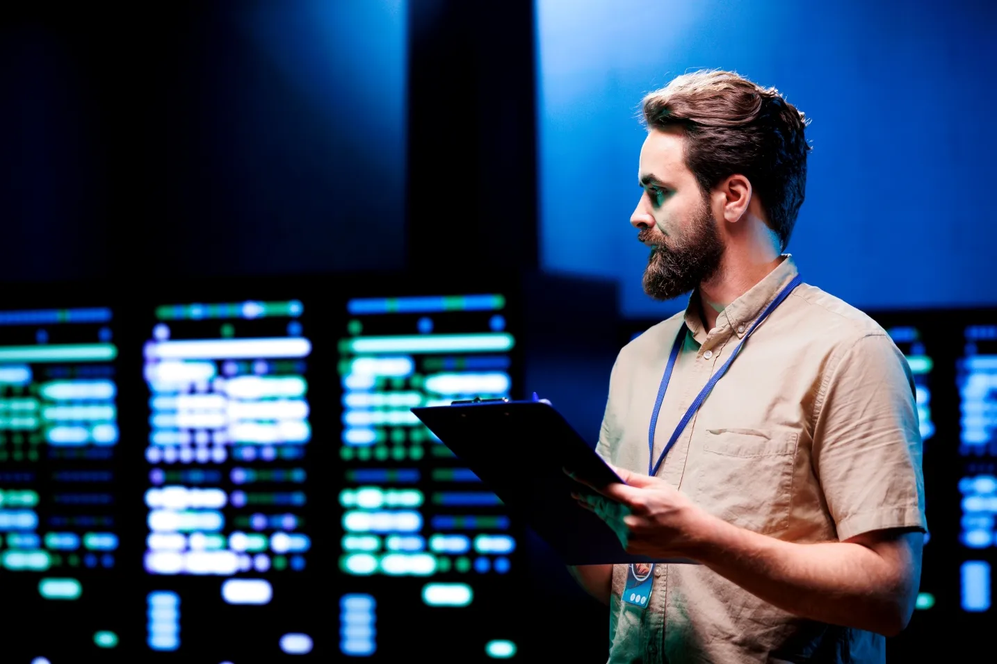 A technical expert reviewing infrastructure and data systems on a tablet in a modern server environment.